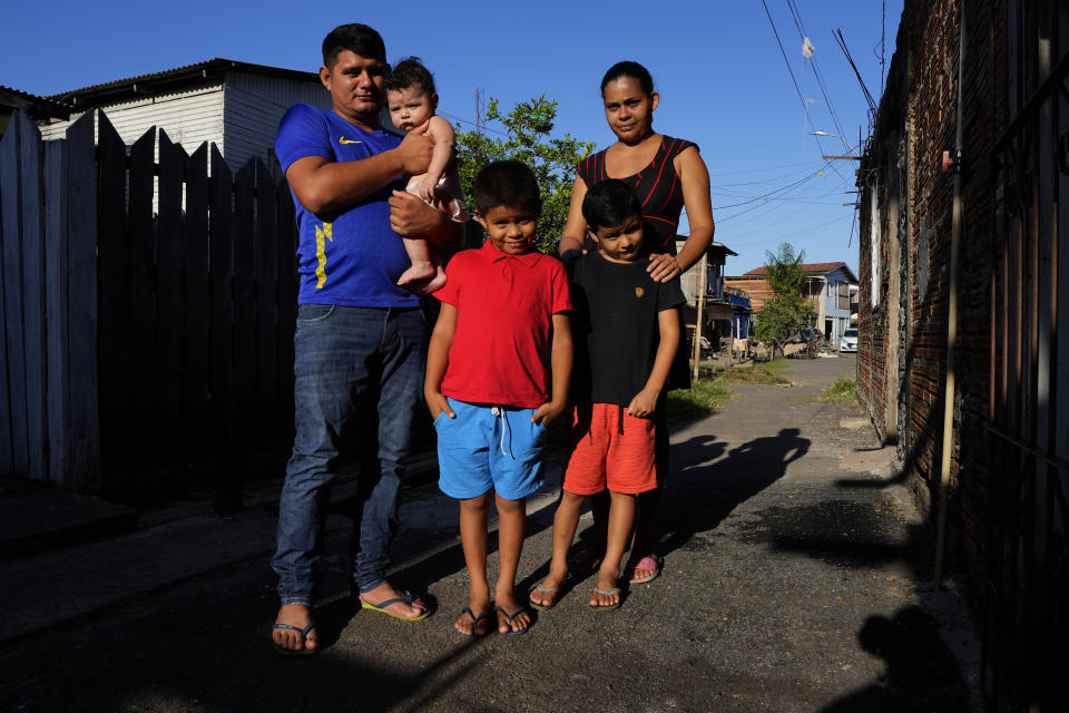 Sabrina Fernandes, her husband Elielson Elinho and their children pose in front of their house, in the Perpetuo Socorro neighborhood, in the city of Macapa, state of Amapa, northern Brazil, Tuesday, Sept. 13, 2022. The family moved in August from Bailique to Macapa due to the advance of seawater and electric outages. (AP Photo/Eraldo Peres)