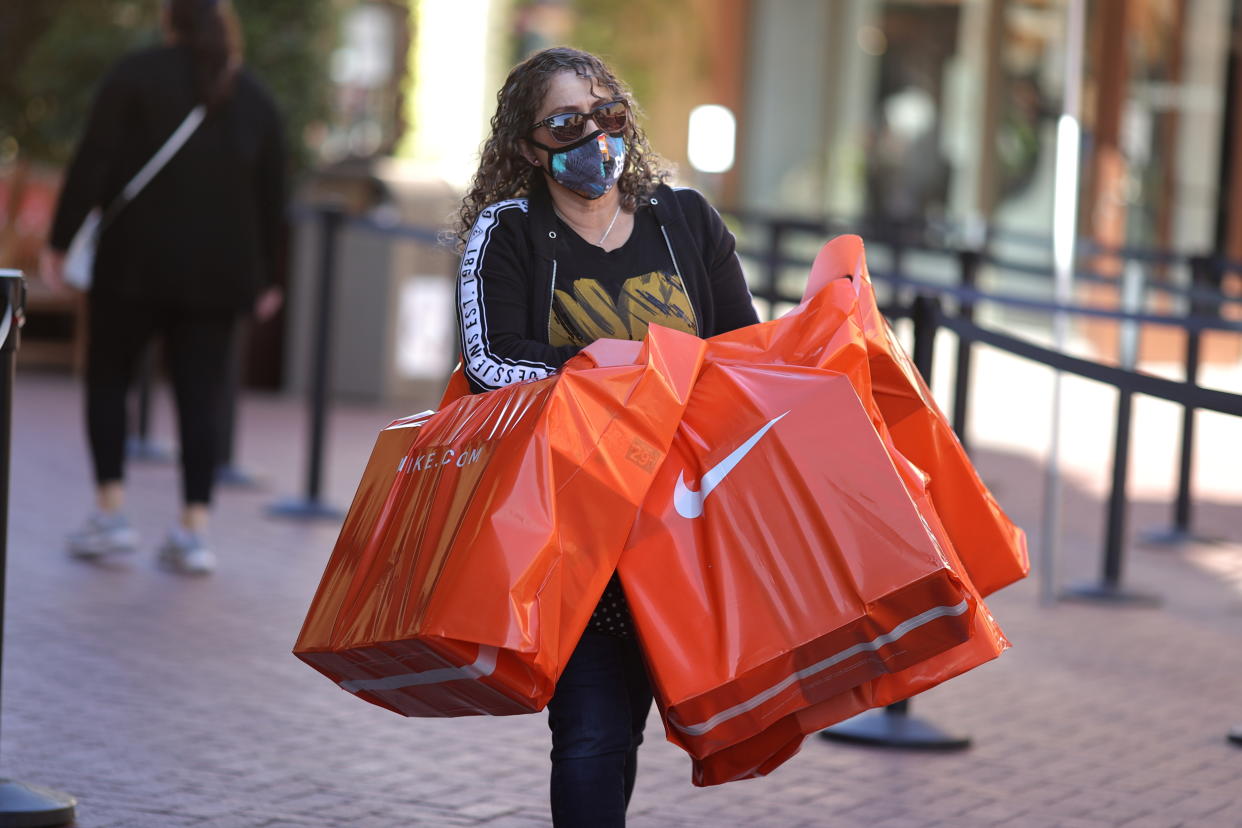 A woman carries Nike shopping bags at the Citadel Outlet mall, as the global outbreak of the coronavirus disease (COVID-19) continues, in Commerce, California, U.S., December 3, 2020. REUTERS/Lucy Nicholson