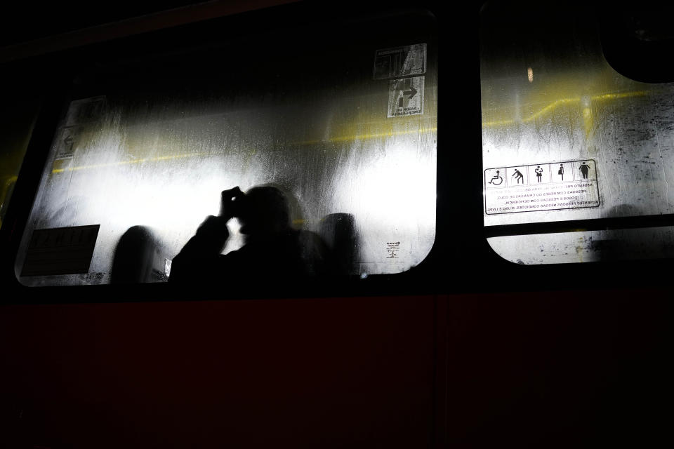 A man rides a public bus during a cloudy and windy night in Rio de Janeiro, Brazil, Thursday, Sept. 29, 2022. (AP Photo/Matias Delacroix)