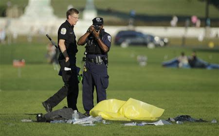 Police officers investigate the scene where a man set himself on fire in front of the U.S. Capitol building on the U.S. National Mall in Washington, October 4, 2013. REUTERS/Gary Cameron