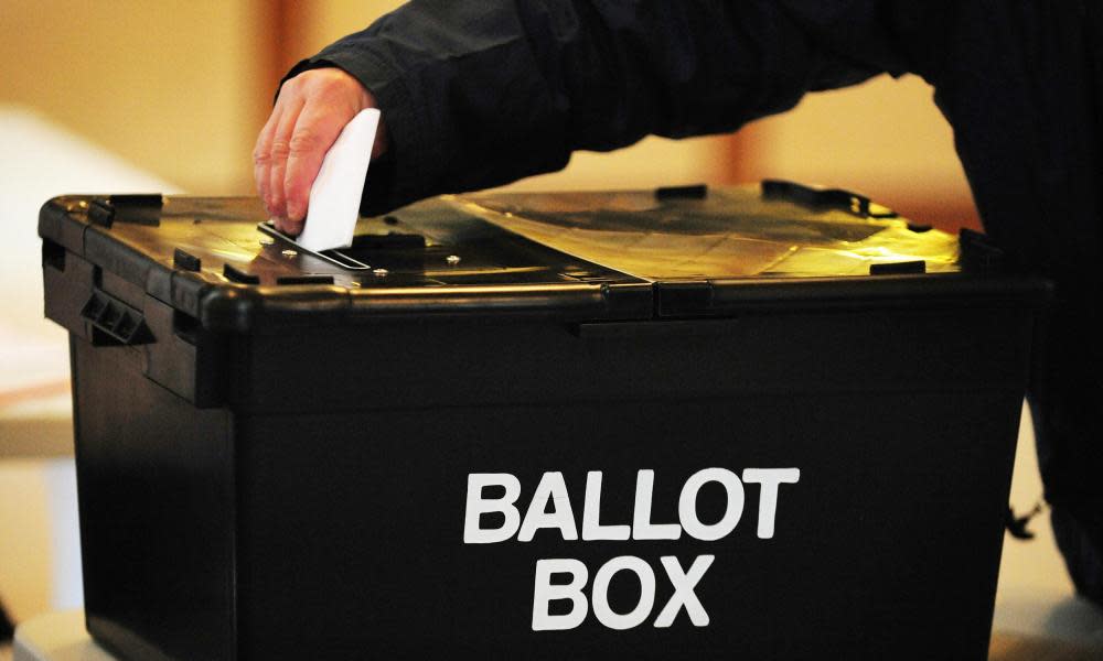 A voter placing a ballot paper in the ballot box at a polling station