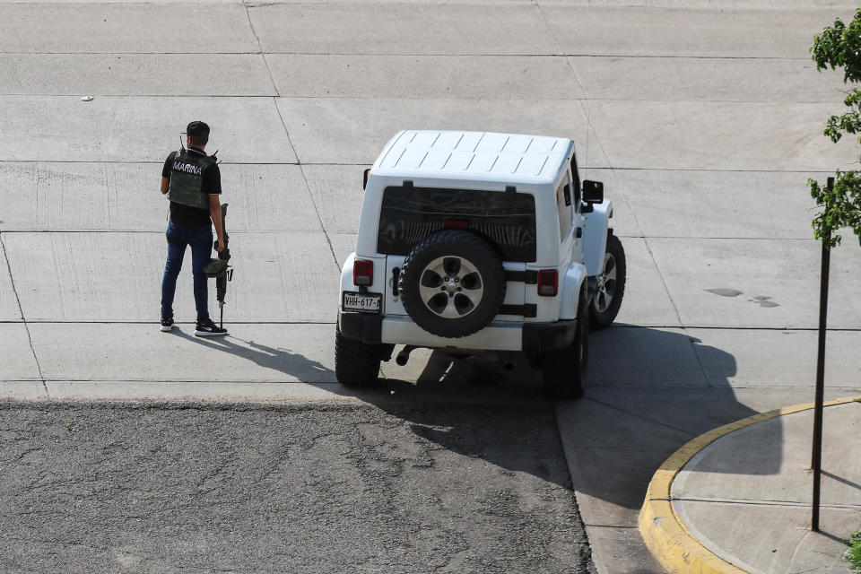 A cartel gunmen wearing a flack jacket stands next to his vehicle during clashes with federal forces following the detention of Ovidio Guzman, son of drug kingpin Joaquin "El Chapo" Guzman, in Culiacan, Sinaloa state, Mexico October 17, 2019. REUTERS/Jesus Bustamante