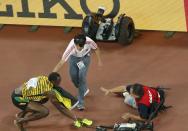 Winner Usain Bolt of crouches after being hit by a cameraman on a Segway (R) after competing at the men's 200 metres final during the 15th IAAF World Championships at the National Stadium in Beijing, China, August 27, 2015. REUTERS/Kim Kyung-Hoon