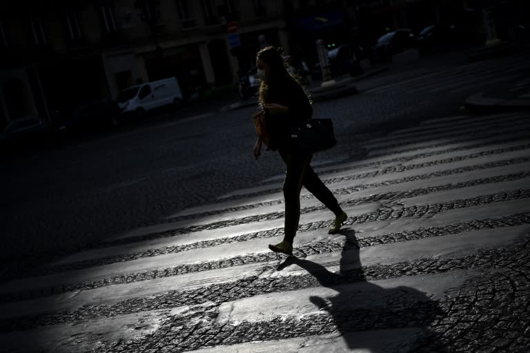 Une femme traverse une rue déserte, le 21 avril 2020 à Paris, pendant le confinement instauré en France pour lutter contre l'épidémie de coronavirus