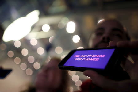 A man displays a protest message on his iPhone at a small rally in support of Apple's refusal to help the FBI access the cell phone of a gunman involved in the killings of 14 people in San Bernardino, in Santa Monica, California, United States, February 23, 2016. REUTERS/Lucy Nicholson