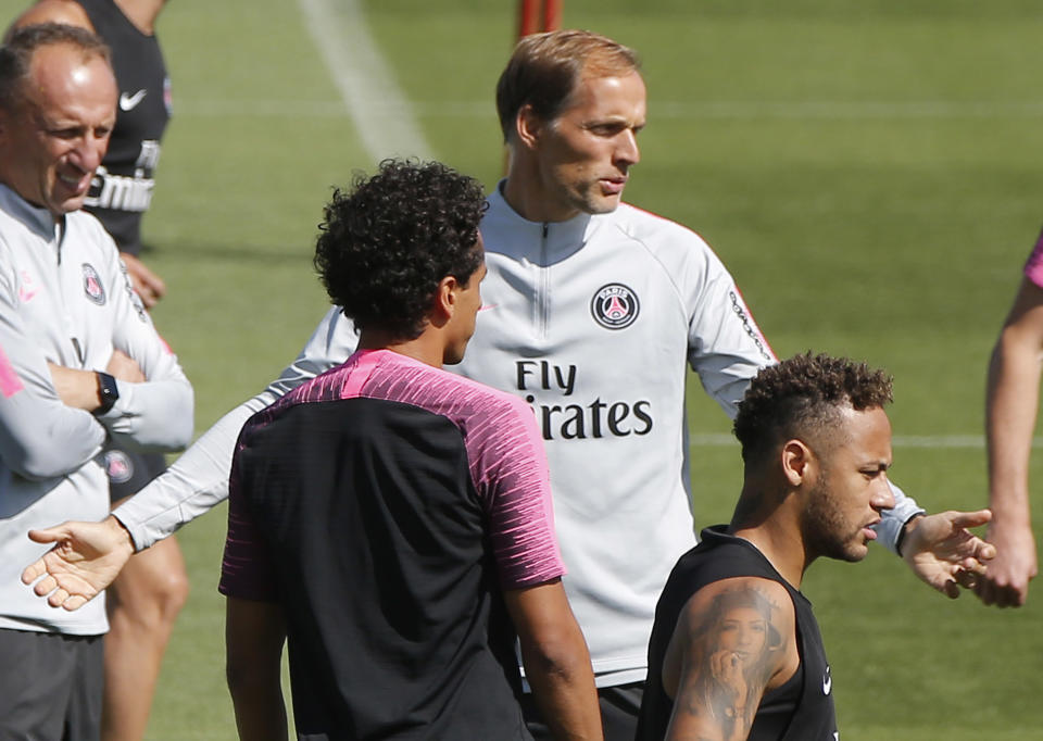 PSG's Marquinhos, left, coach Thomas Tuchel, and Neymar attend a training session at the Camp des Loges training center in Saint Germain en Laye, west of Paris, France, Saturday, Aug. 11, 2018. Paris Saint Germain will face Caen during their first match of the French League One session at Parc des Princes stadium on Sunday Aug. 12, 2018. (AP Photo/Michel Euler)