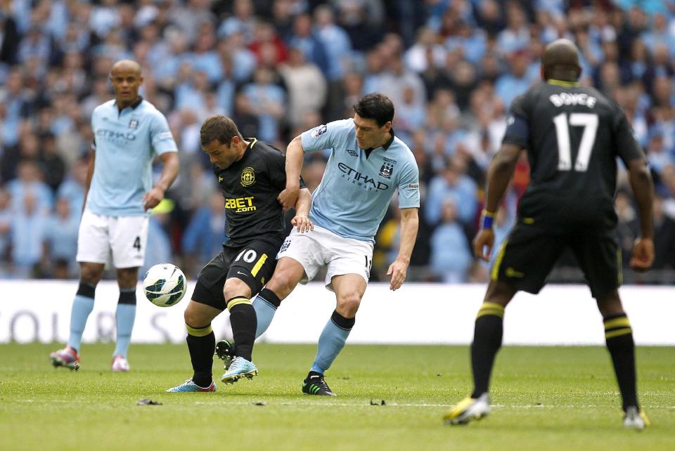 Manchester City's Gareth Barry (centre right) and Wigan Athletic's Shaun Maloney (centre left) battle for the ball