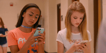 two middle school girls texting in the movie "Eighth Grade"