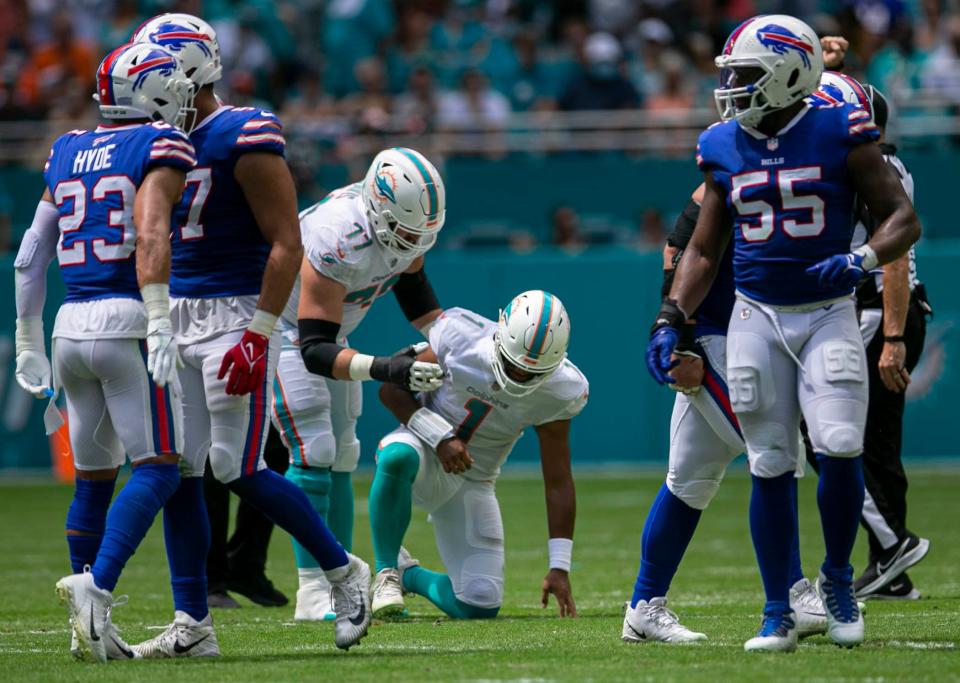 Miami Dolphins Miami Dolphins quarterback Tua Tagovailoa (1), is help of the ground by Miami Dolphins offensive guard Jesse Davis (77), after being sacked by Buffalo Bills offensive tackle Daryl Williams (75) during first quarter action of their NFL game at Hard Rock Stadium Sunday in Miami Gardens. Tagovailoa did not return to action. 