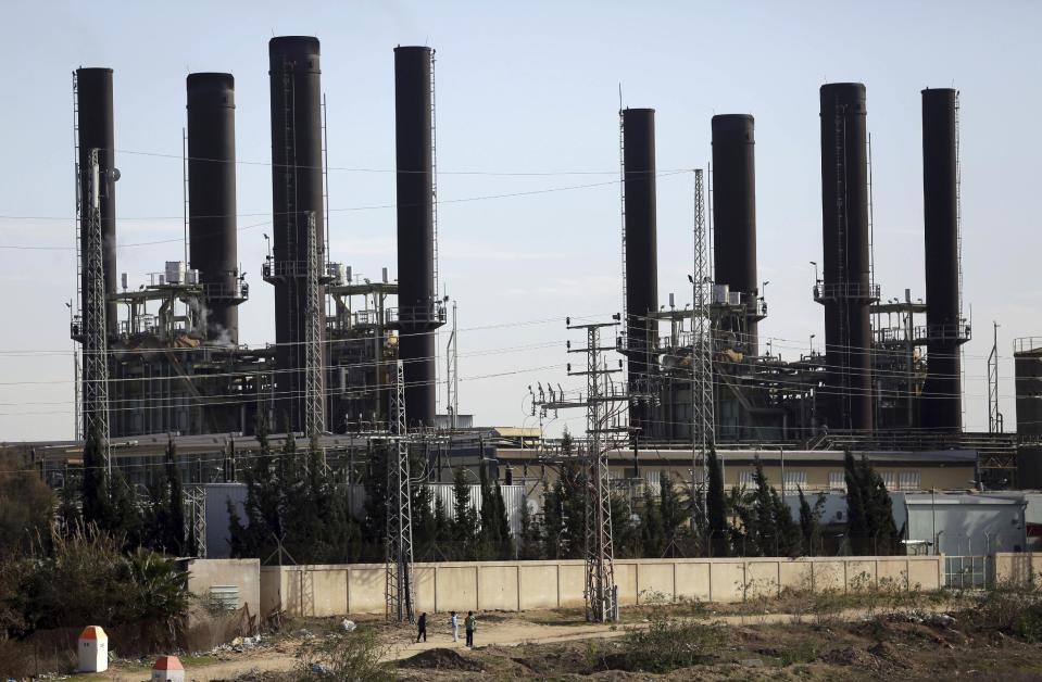 Palestinian children play next to Gaza's power plant in the town of Nusairat, central Gaza Strip, Thursday, Jan. 12, 2017. Thousands of people took to the streets on Thursday to protest chronic power cuts in the Hamas-ruled Gaza Strip, in one of the largest unauthorized protests in the territory since the Islamic militant group took power a decade ago. (AP Photo/ Khalil Hamra)