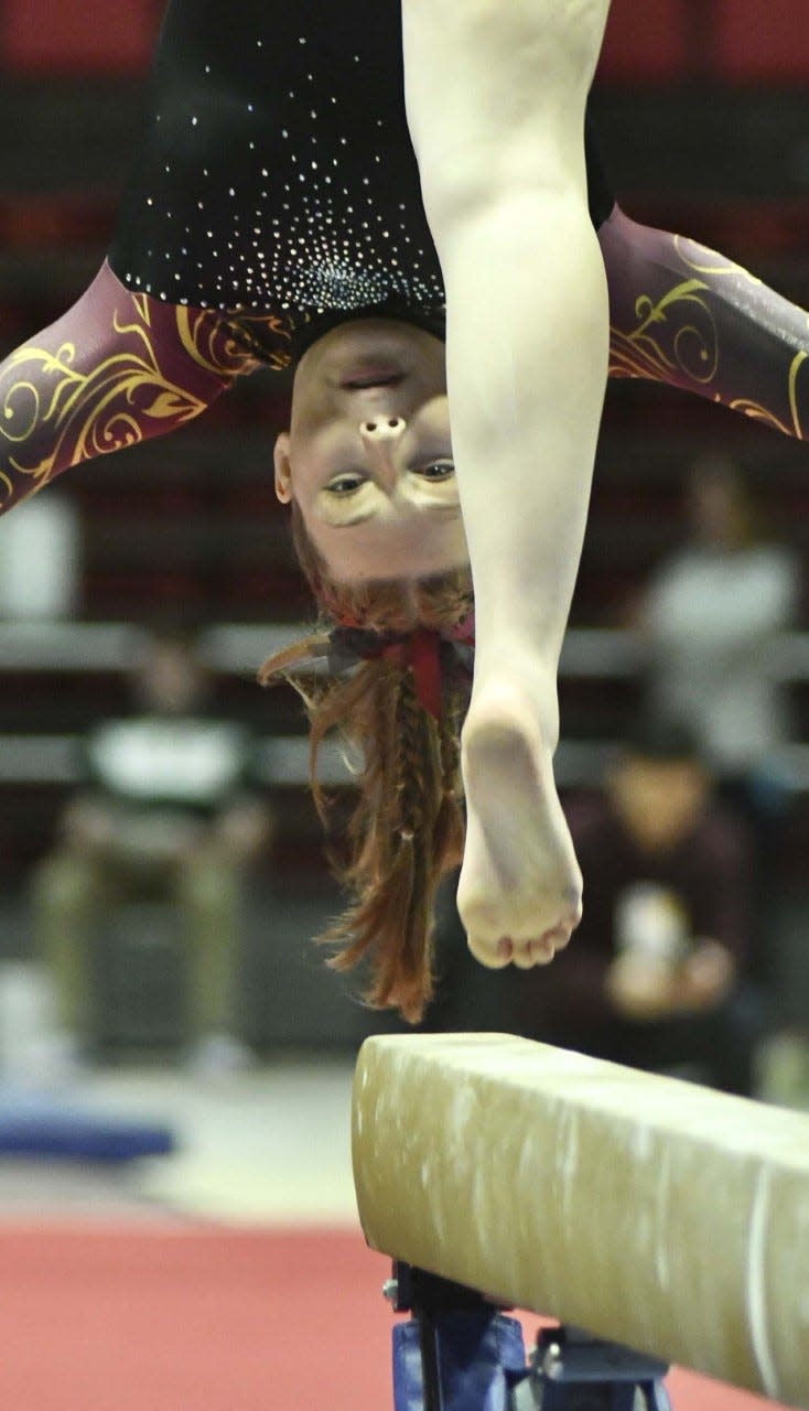 Bloomington North's Claire Dann does her dismount at the end of her beam routine in the IHSAA state gymnastics finals at Ball State on Saturday, March 11, 2023.