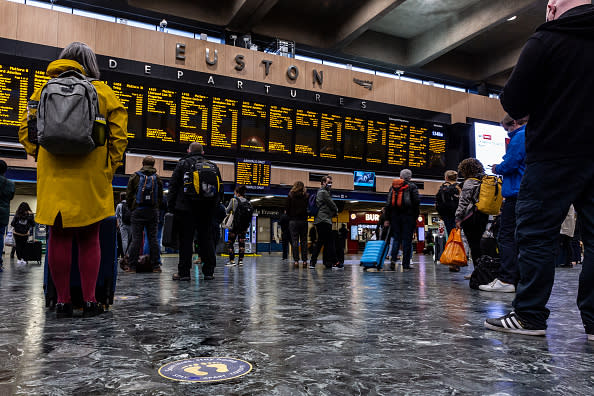 Commuters in protective face masks are seen at Euston Station waiting for their trains and observing social distancing in London, England.