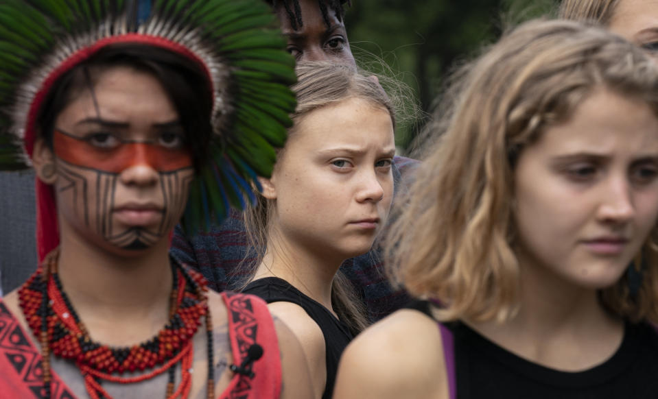 Swedish activist Greta Thunberg, center, who has called on world leaders to step up their efforts against global warming, stands with indigenous people of the Americas and others, during remarks by Sen. Ed Markey, D-Mass., chairman of the Senate Climate Change Task Force, at a news conference at the Capitol in Washington, Tuesday, Sept. 17, 2019. (AP Photo/J. Scott Applewhite)