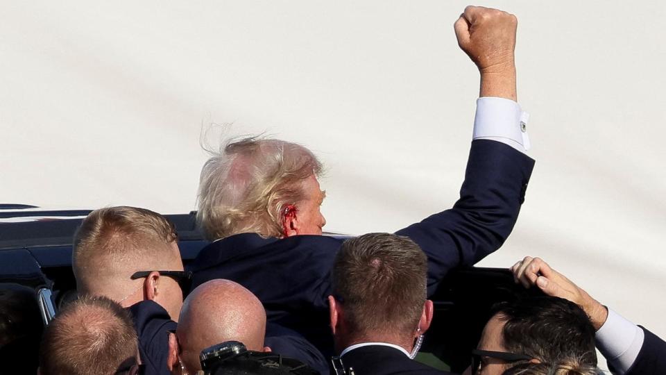 PHOTO: Republican presidential candidate and former U.S. President Donald Trump gestures as he is assisted by security personnel after gunfire rang out during a campaign rally in Butler, Pennsylvania, July 13, 2024.  (Brendan Mcdermid/Reuters)