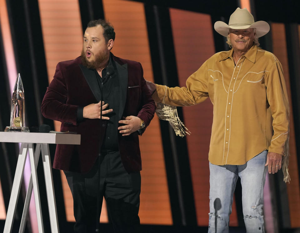 Luke Combs, left, accepts the award for entertainer of the year as presenter Alan Jackson looks on at the 55th annual CMA Awards on Wednesday, Nov. 10, 2021, at the Bridgestone Arena in Nashville, Tenn. (AP Photo/Mark Humphrey)