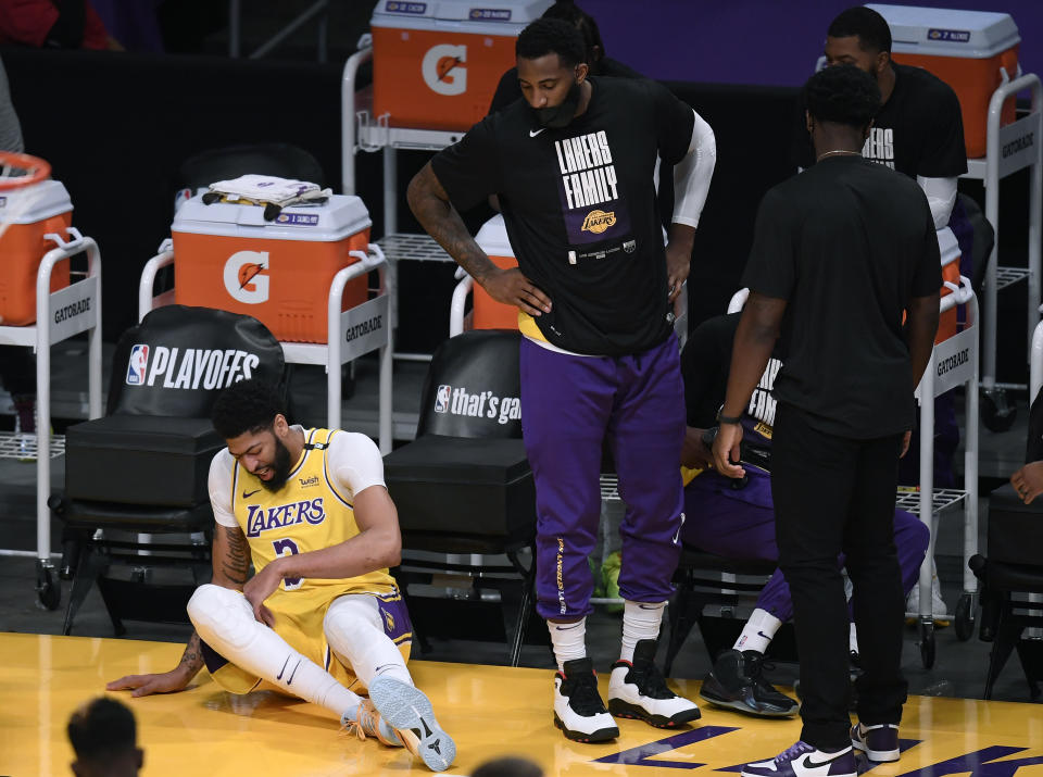 Anthony Davis of the Los Angeles Lakers falls at the Laker bench