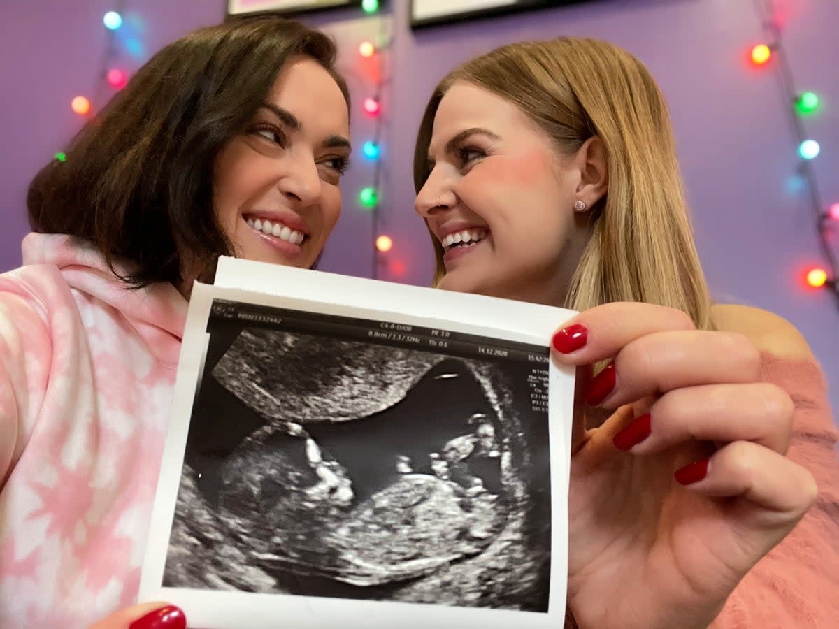 Rose and Rosie holding up their baby scan