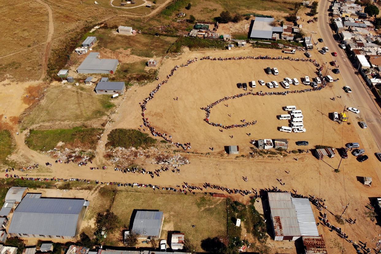 Thousands line up to receive food handouts in the Olievenhoutbos township of Midrand, South Africa on Saturday, May 2, 2020. Although South Africa began a phased easing of its strict lockdown measures on May 1, the confirmed cases of coronavirus continue to increase.
