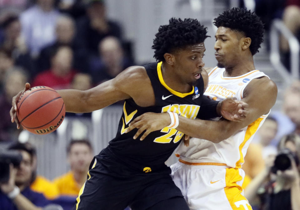 Iowa's Tyler Cook, left, drives past Tennessee's Kyle Alexander in the first half during a second round men's college basketball game in the NCAA Tournament in Columbus, Ohio, Sunday, March 24, 2019. (AP Photo/John Minchillo)