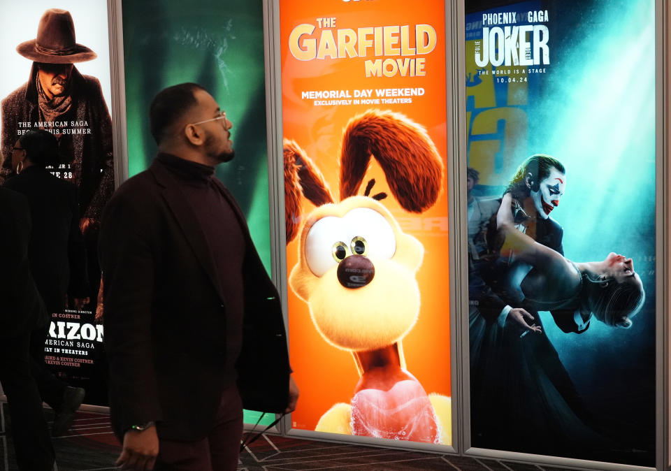 Un asistente pasa junto anuncios de próximas películas, incluidas "The Garfield Movie" y "Joker: Folie a Deux", el día inaugural de CinemaCon 2024 en el Caesars Palace, el lunes 8 de abril de 2024, en Las Vegas. La convención de cuatro días de la Asociación Nacional de Propietarios de Cines se extenderá hasta el jueves. (Foto AP/Chris Pizzello)