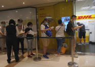 People queue up outside the DHL Express store in Hong Kong, Monday, June 1, 2020. Throngs of people lined up at DHL courier outlets across the city on Monday, many to send documents to the U.K. to apply for or renew what is known as a British National (Overseas) passport. (AP Photo/Vincent Yu)