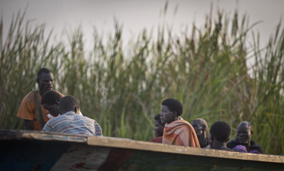 In this photo taken Thursday, Jan. 2, 2014, displaced people arrive by river barge from Bor, some of the thousands who fled the recent fighting between government and rebel forces in Bor by boat across the White Nile, in the town of Awerial, South Sudan. (AP Photo/Ben Curtis)