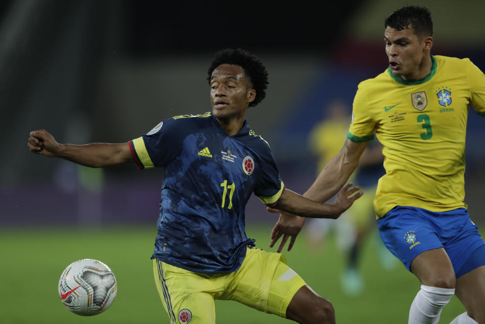 Colombia's Juan Cuadrado, left, and Brazil's Thiago Silva battle for the ball during a Copa America soccer match at Nilton Santos stadium in Rio de Janeiro, Brazil, Wednesday, June 23, 2021. (AP Photo/Silvia Izquierdo)