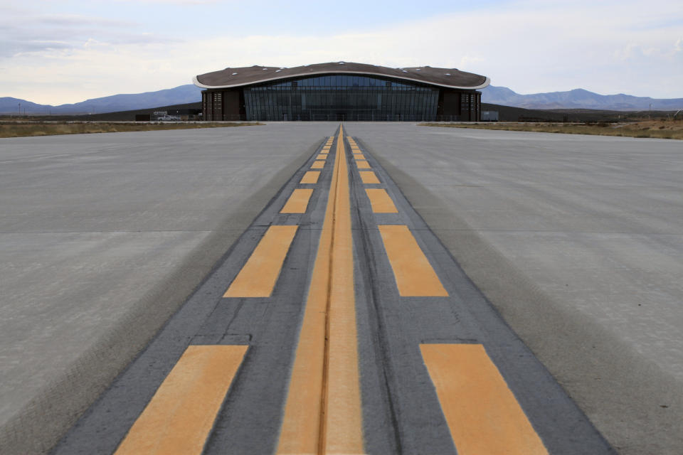 FILE - This Dec. 9, 2014, file photo shows the taxiway leading to the hangar at Spaceport America in Upham, N.M. British billionaire Richard Branson is taking another concrete step toward offering rides into the close reaches of space for paying passengers. Branson announced Friday, May 10, 2019, that Virgin Galactic will immediately begin shifting operations from California to the spaceport and specialized runway in the New Mexico desert in final preparations for commercial flights. He says Virgin Galactic's development and testing program has advanced enough to make the move, which will continue through the summer. (AP Photo/Susan Montoya Bryan, file)