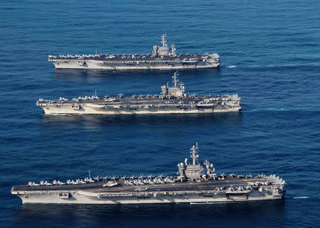 FILE PHOTO - The aircraft carriers USS Ronald Reagan (CVN 76), USS Theodore Roosevelt (CVN 71) and USS Nimitz (CVN 68) are underway, conducting operations, in international waters as part of a three-carrier strike force exercise in western Pacific, November 12, 2017. Courtesy James Griffin/U.S. Navy/Handout via REUTERS/File Photo