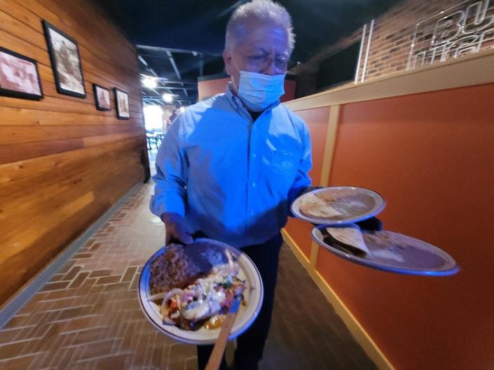 Cresencio Gonzalez takes out an order at TAXCO Mexican Grill in April 2021 in this Gazette file photograph.
