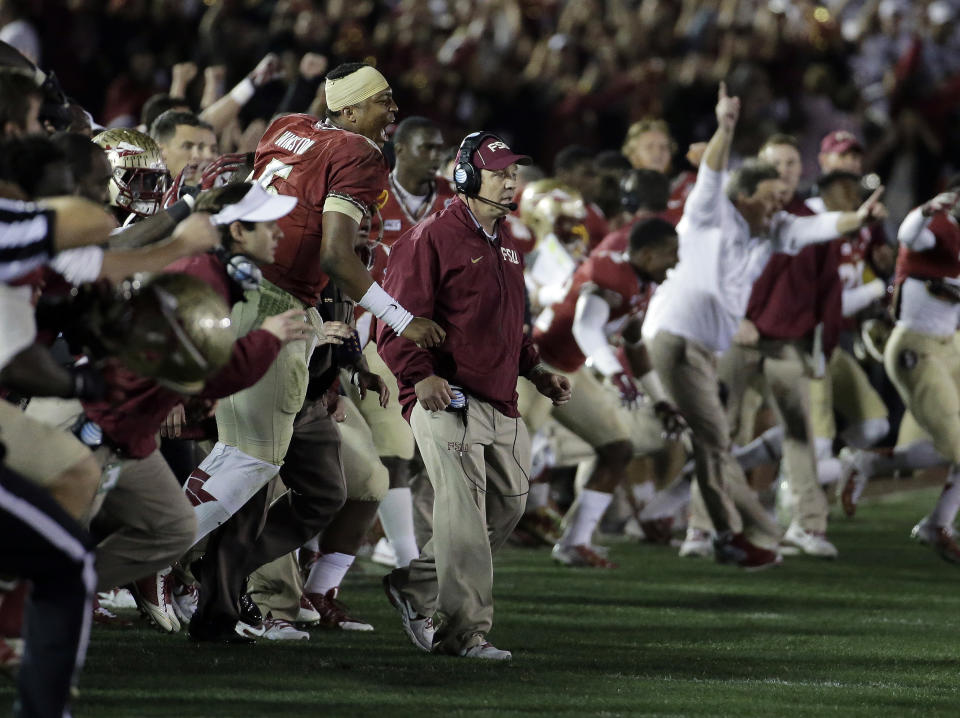 El entrenador Jimgo Fisher, de Florida State, salta al terreno junto con varios jugadores y asistentes, luego de conquistar el título frente a Auburn, el lunes 6 de enero de 2014, en Pasadena, California (AP Foto/Chris Carlson)