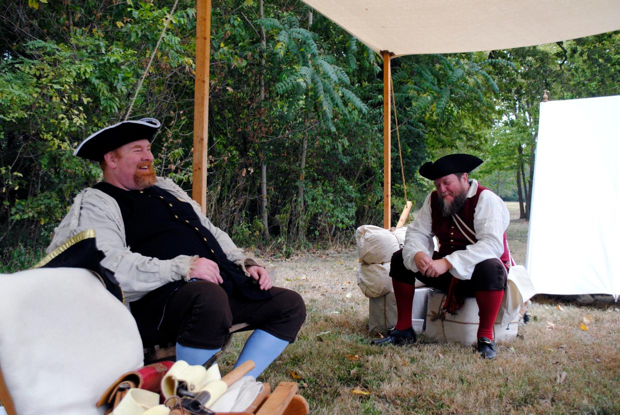 Patrick Mills (left) and John Givans laugh and talk as they portray post-Revolution Americans at a previous Old Town Waverly Park Festival event. The event featured numerous old-time, period artists and reenactors.