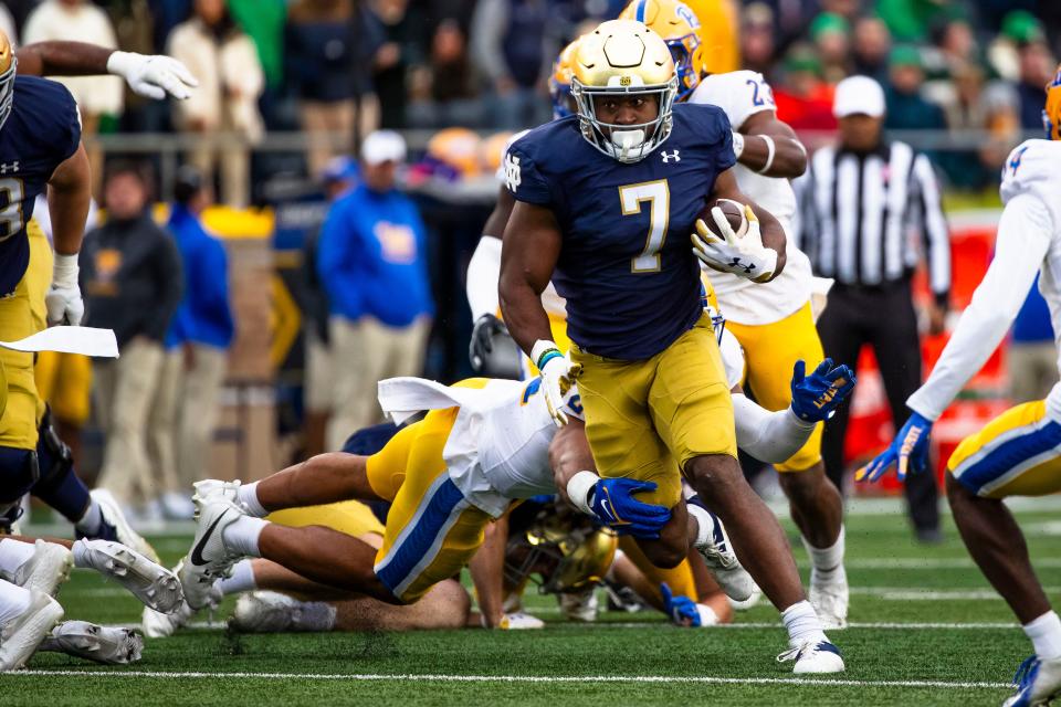 Notre Dame running back Audric Estime (7) gets past Pittsburgh line backer Shayne Simon, back, during the second half of an NCAA college football game Saturday, Oct. 28, 2023, in South Bend, Ind. (AP Photo/Michael Caterina)