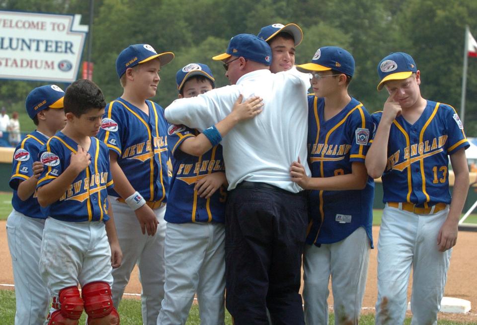 Lincoln coach Charlie Hien consoles players after their loss to the California team that was the eventual runner-up at the 2004 Little League World Series.