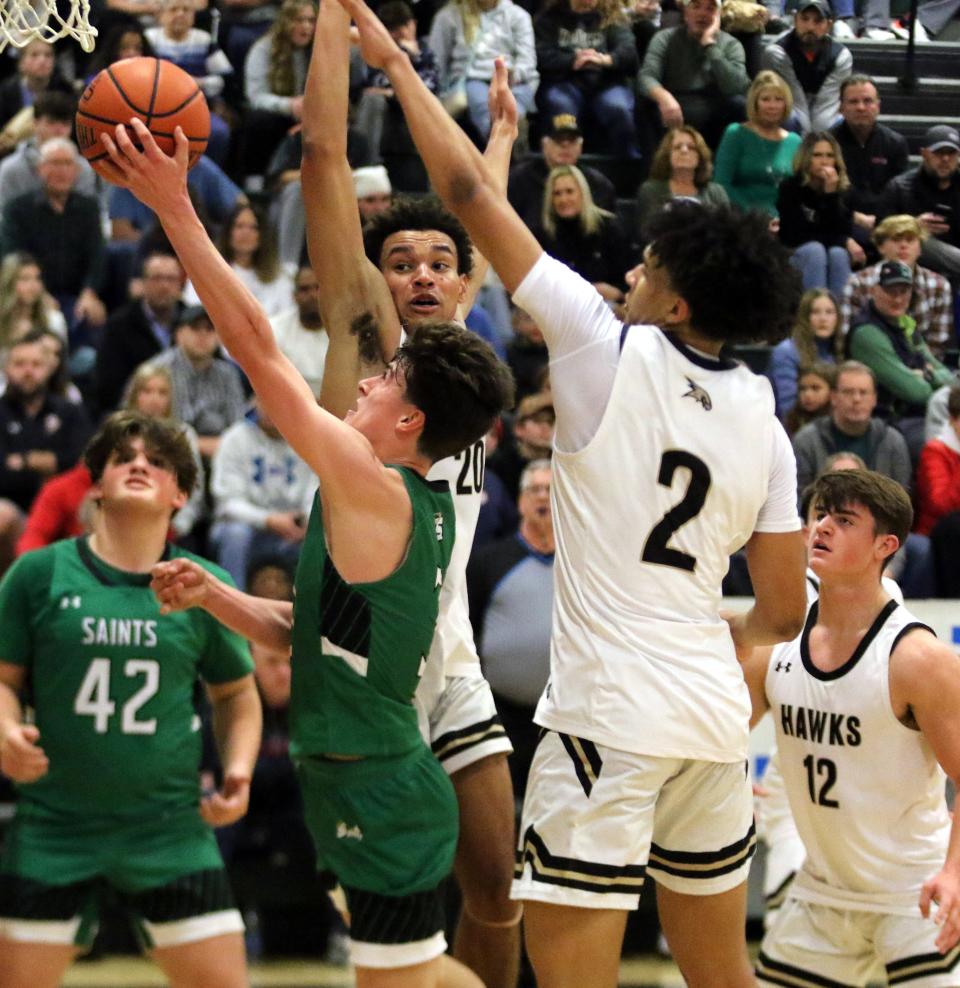 Binghamton Seton Catholic Central's Andrew Erickson goes up for a shot as Corning's Reed Walrath (20) and Isaiah Henderson (2) defend during the Hawks' 74-63 overtime win in the Boys Regional Division 2 championship game at the Josh Palmer Fund Clarion Classic on Dec. 30, 2022 at Elmira High School.