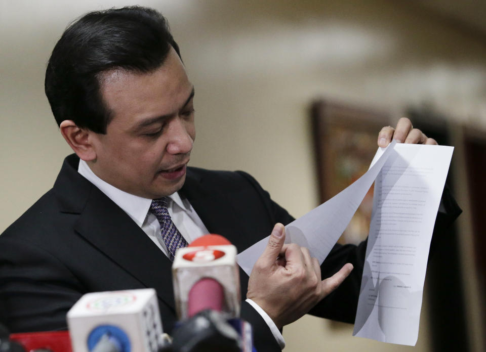 Philippine opposition Sen. Antonio Trillanes IV shows to reporters a copy of his amnesty documents outside his office where he remains holed up in the Philippine Senate in suburban Pasay city, south of Manila, Philippines on Tuesday, Sept. 11, 2018. Trillanes has been staying inside his senate office for over a week to avoid an arrest order by Philippine President Rodrigo Duterte. (AP Photo/Aaron Favila)