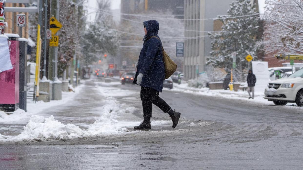 Someone crosses a snowy street in Ottawa last November, when it was looking similar to Thursday morning. (Francis Ferland/CBC - image credit)