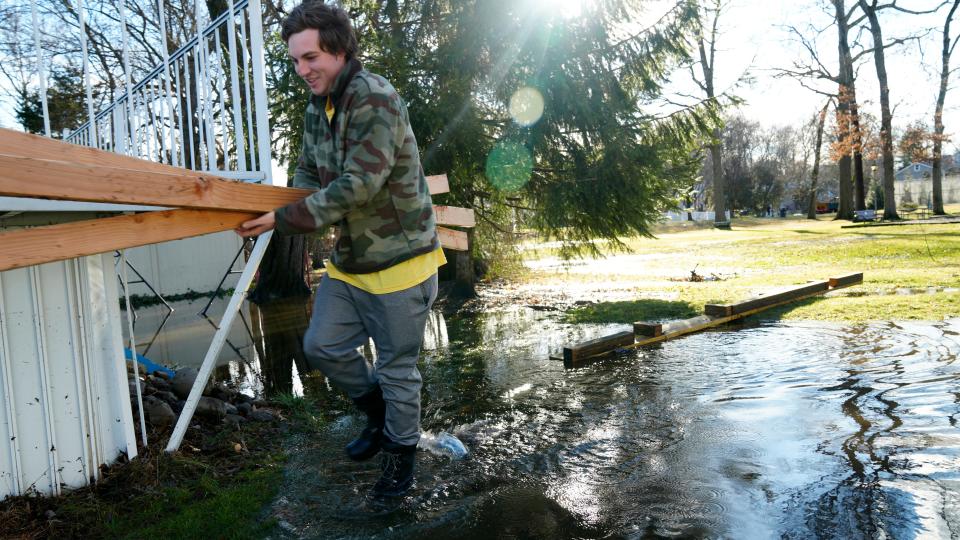(Image for video promo) Daniel B. Atkins, 23, is shown in the flooded backyard of his Harding Avenue home, in Westwood, as he holds two pieces of lumber, Wednesday, January 10, 2024.