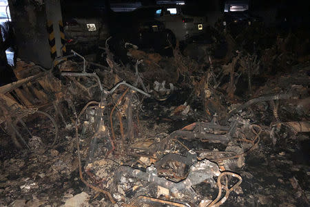 Motorbikes are seen burned down in a parking lot after a fire broke out in an apartment block in Ho Chi Minh City, Vietnam March 23, 2018. REUTERS/Stringer