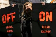 A protester holds posters while people take part in a protest about climate change around New York City Hall at lower Manhattan, New York, November 29, 2015, a day before the start of the Paris Climate Change Conference (COP21). REUTERS/Eduardo Munoz