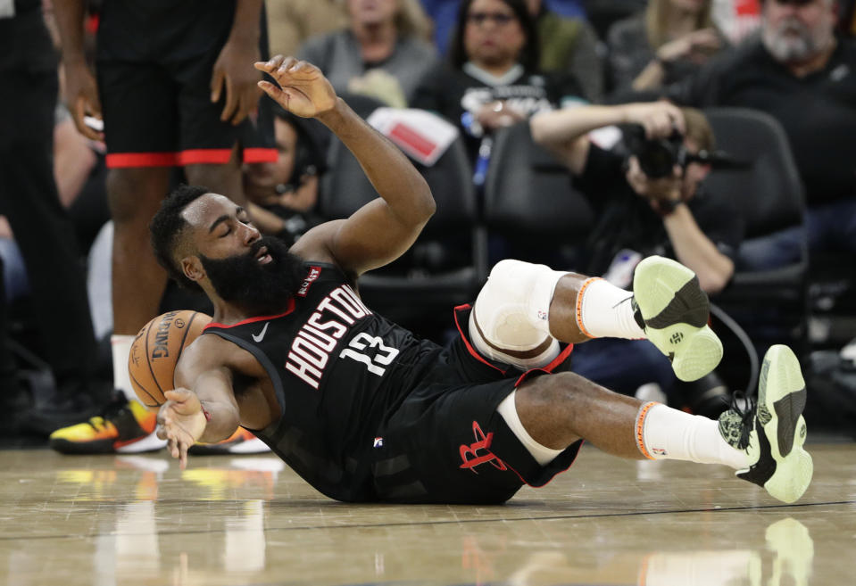 Houston Rockets guard James Harden (13) hits the court after he was fouled during the second half of an NBA basketball game against the San Antonio Spurs, in San Antonio, Tuesday, Dec. 3, 2019. San Antonio won 135-133 in double overtime. (AP Photo/Eric Gay)