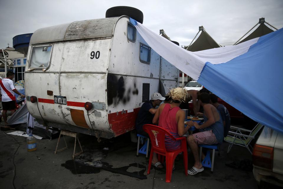 Argentinian fans eat lunch next to their motorhome as they wait out for Sunday's World Cup final between Argentina and Germany at the Terreirao do Samba in Rio de Janeiro