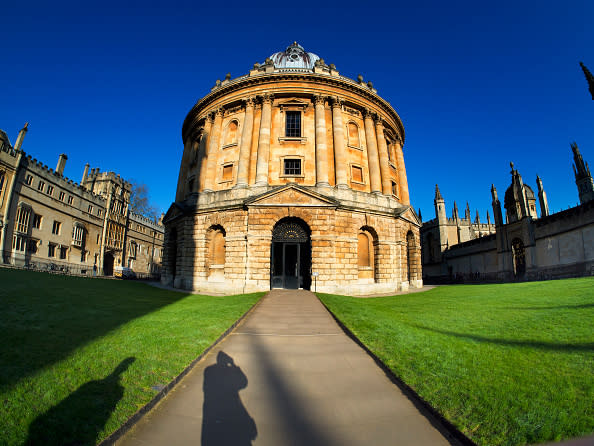 Historic round building with dome and pathway leading to the entrance; shadow of a person in the foreground