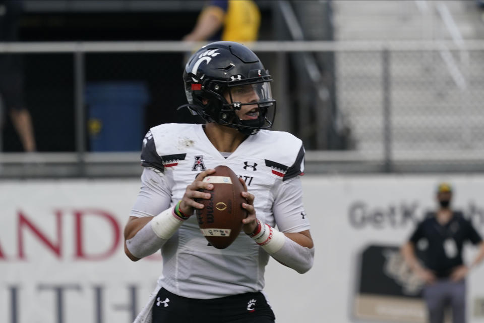 Cincinnati quarterback Desmond Ridder looks for a receiver during the first half of an NCAA college football game, Saturday, Nov. 21, 2020, in Orlando, Fla. (AP Photo/John Raoux)