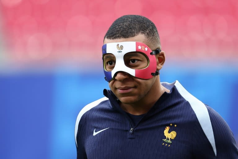 <a class="link " href="https://sports.yahoo.com/soccer/players/3893765/" data-i13n="sec:content-canvas;subsec:anchor_text;elm:context_link" data-ylk="slk:Kylian Mbappe;sec:content-canvas;subsec:anchor_text;elm:context_link;itc:0">Kylian Mbappe</a> arrives wearing a face mask to take part in a France team training session on Thursday (FRANCK FIFE)