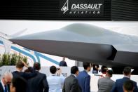 Visitors look at the French-German-Spanish New Generation Fighter (NGF) model during the 53rd International Paris Air Show at Le Bourget Airport near Paris