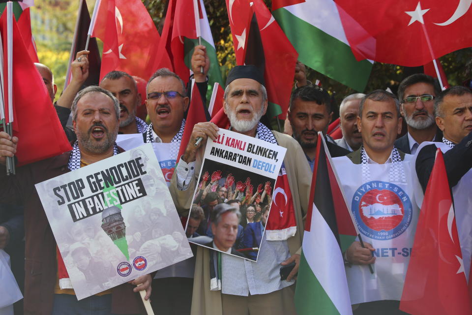 People shout slogans during a pro Palestinians protest outside U.S. embassy in Ankara, Turkey, Monday, Nov. 6, 2023. U.S. Secretary of State Antony Blinken is wrapping up a gruelling Middle East diplomatic tour in Turkey after only limited success in his furious efforts to forge a regional consensus on how best to ease civilian suffering in Gaza as Israel intensifies its war against Hamas. Board in the centre reads in Turkish: ""Blinken with blood on his hands, gets out of Ankara!". (AP Photo/Ali Unal)