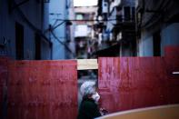 A resident wearing a face mask is seen at a blocked residential area after the lockdown was lifted in Wuhan