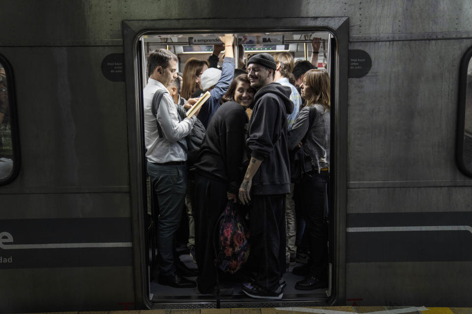 Una pareja sonríe abrazada en un vagón de metro atestado en Buenos Aires, Argentina, el 12 de abril de 2024. (AP Foto/Rodrigo Abd)