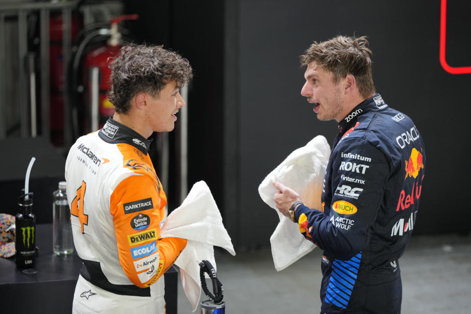 McLaren driver Lando Norris of Britain, left, talks with second placed Red Bull driver Max Verstappen of the Netherlands after qualifying session of the Singapore Formula One Grand Prix at the Marina Bay Street Circuit, in Singapore, Saturday, Sept. 21, 2024. (AP Photo/Vincent Thian)